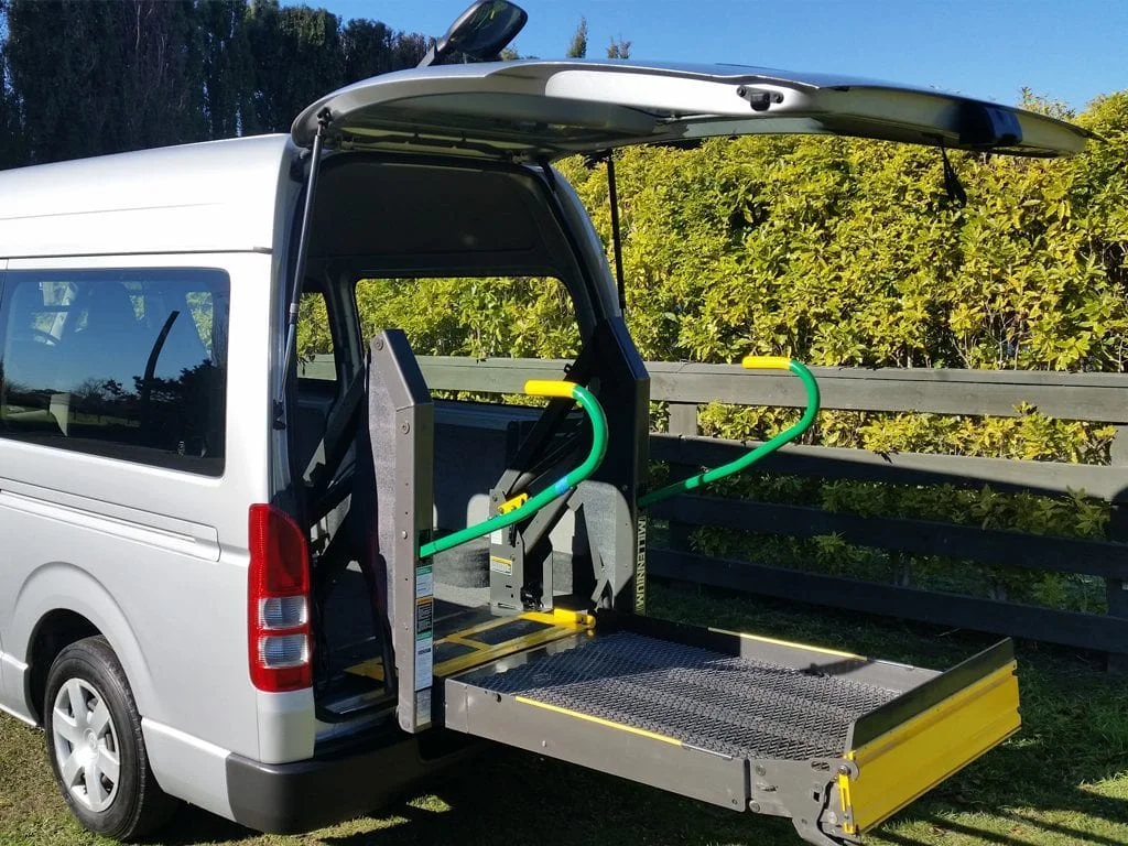 Rear wheelchair lift extended from a representative 7-seater Toyota Hiace